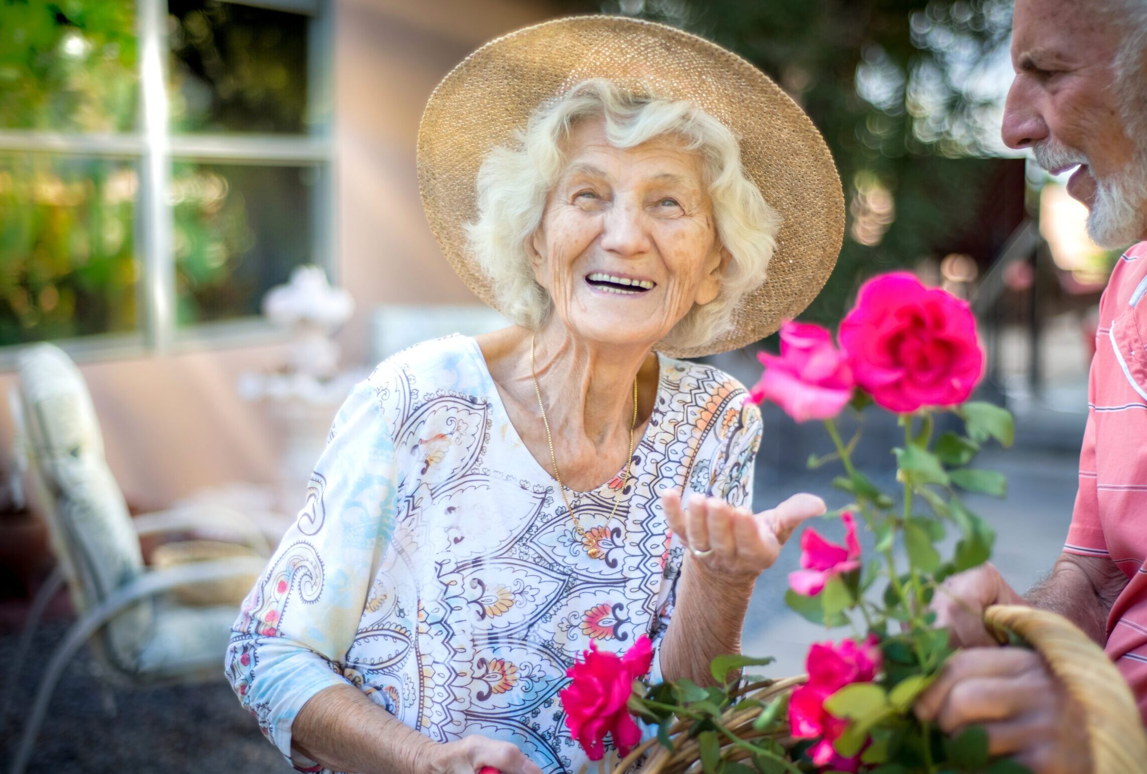 older adult senior woman with sun hat and flowers